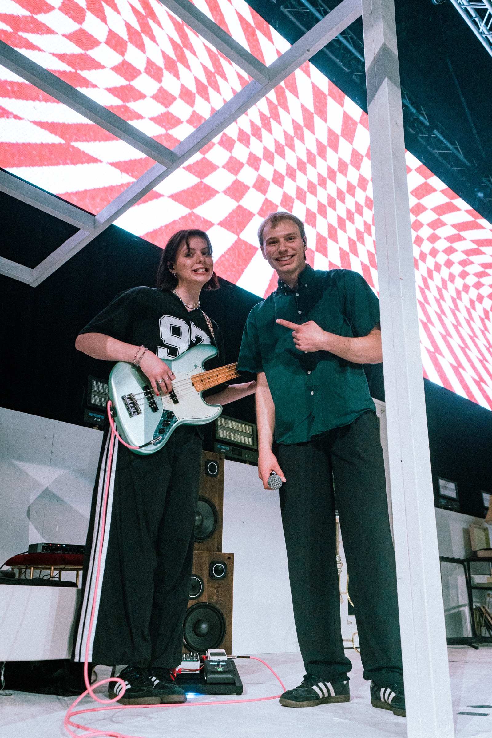 Two Rally team members on stage with a bass guitar and microphone